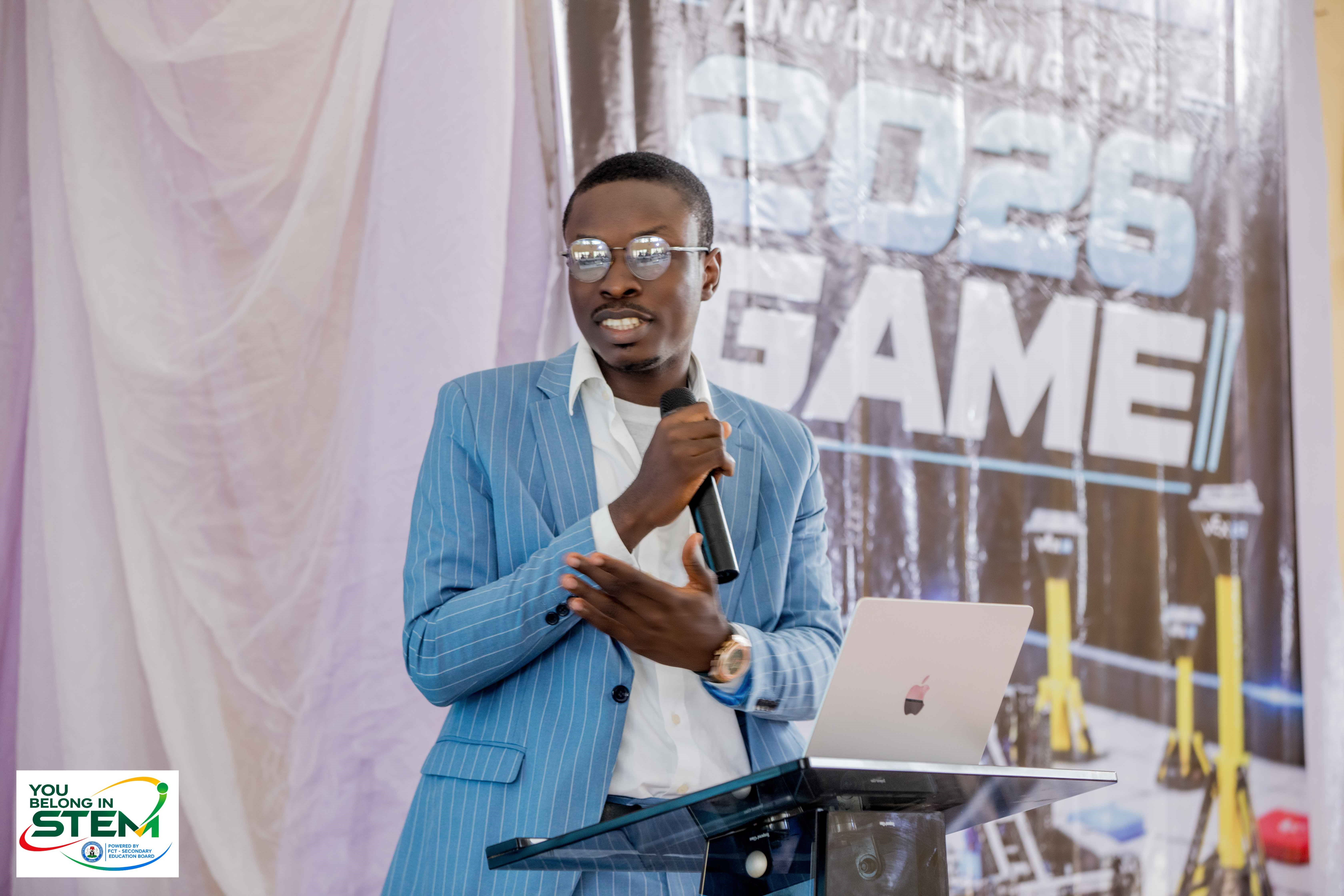 Samuel Nzube, Programme Director for You Belong in STEM, presenting at the podium
